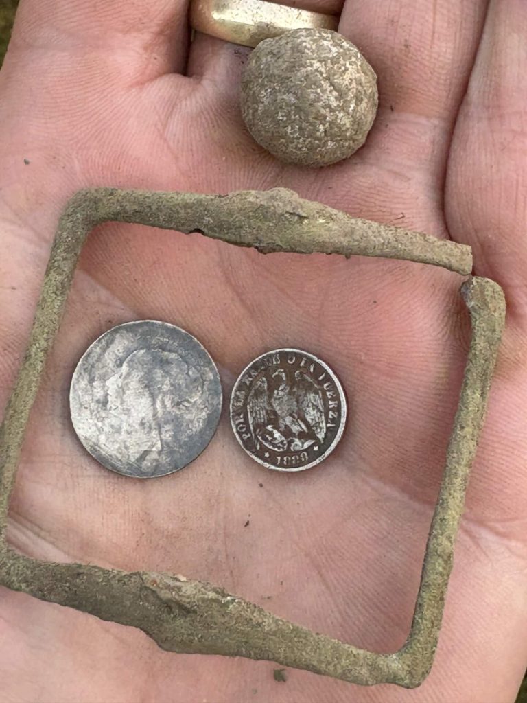 some metal detecting finds, including an international silver coins and a Vicky 6 pemcve.