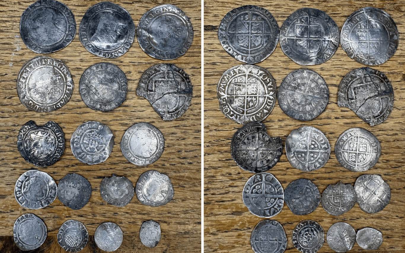 A collection of various medieval and post medieval silver hammered coins displayed on a wooden surface.