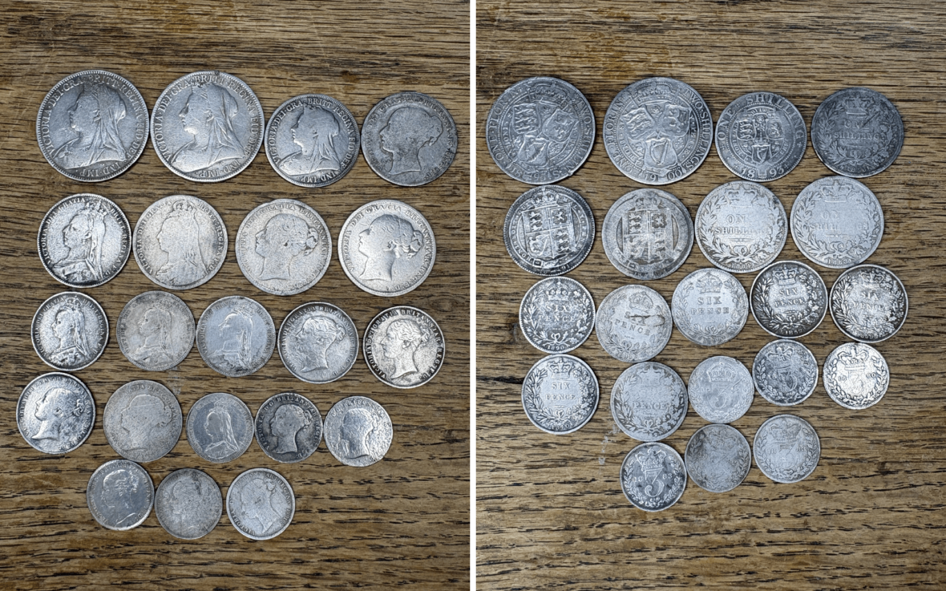 A collection of Queen Victoria silver coins displayed on a wooden surface.