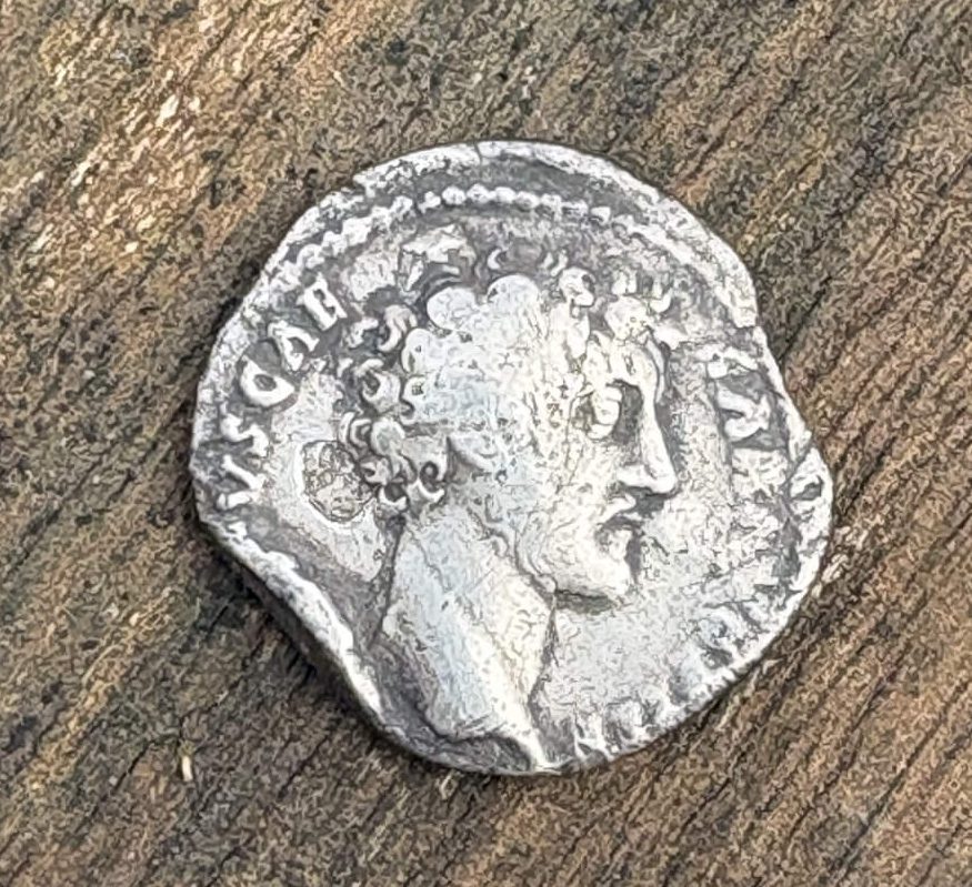 Ancient silver coin featuring a profile portrait of a Roman Emperor Pius.