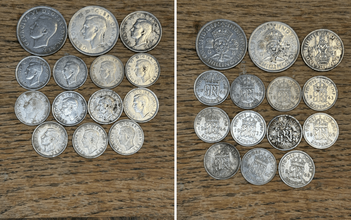 A collection of George 6th silver coins displayed on a wooden surface.