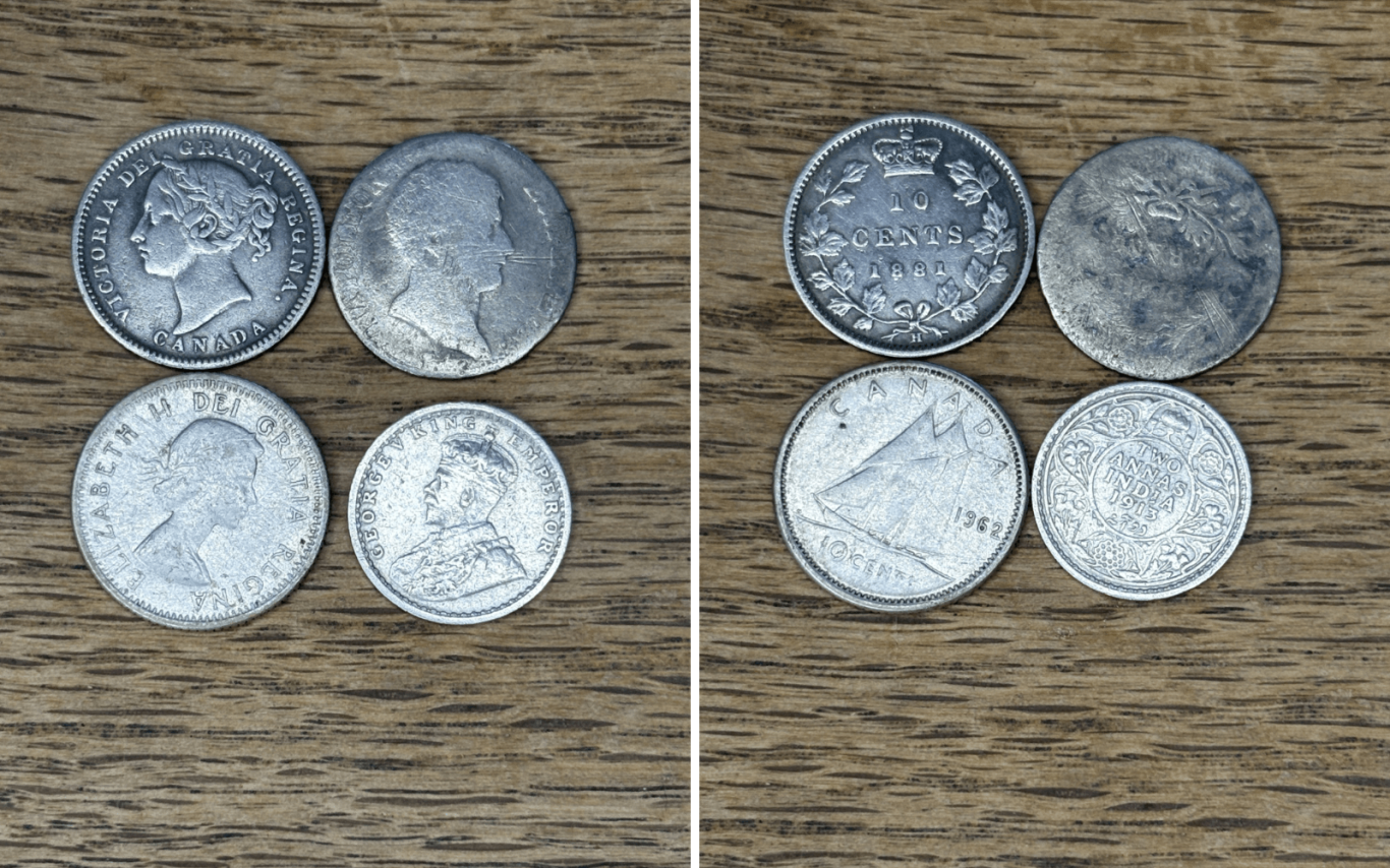 A collection of international silver coins displayed on a wooden surface.