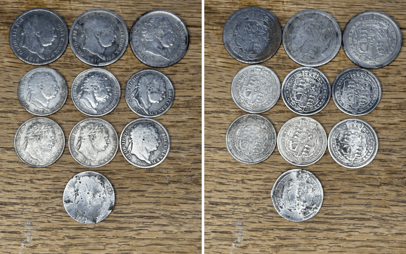 A collection of William 3rd silver coins displayed on a wooden surface.